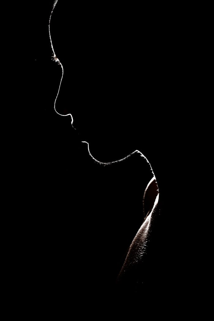 Artistic silhouette of a person against a dark background, evoking mystery and solitude.